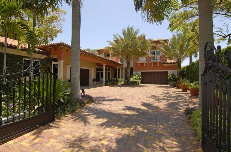 Mediterranean villa with white stucco, bougainvillea, and three-car garage
