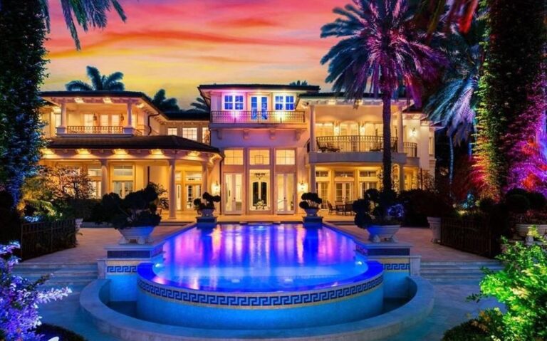 Modern luxury residential home at night with illuminated pool